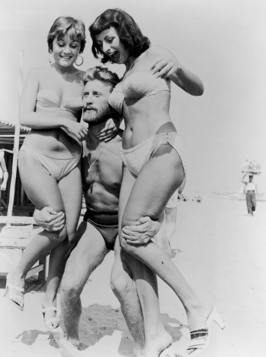 Kirk Douglas  pe plaja cu doua admiratoare in timpul Festivalului de la Vanetia din 1953