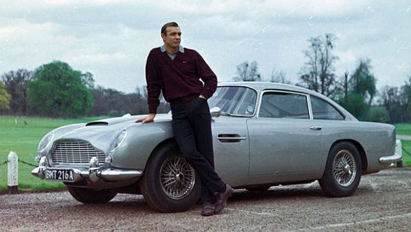  Aston Martin DB5 a aparut pentru prima data in Goldfinger (1964) cu Sean Connery, Gert Fröbe si Honor Blackman. Este pe rand cea mai faimoasa masina James Bond si cea mai iconica masina din istoria filmului. Masina era dotata cu un scut antiglont si avea arme automate.